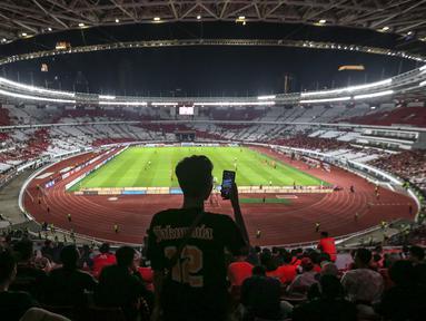 Seorang pendukung Persija Jakarta mengabadikan momen menggunakan gawainya sebelum laga terakhir BRI Liga 1 2022/2023 antara Persija Jakarta melawan PSS Sleman di Stadion Utama Gelora Bung Karno (SUGBK), Senayan, Jakarta, Sabtu (15/04/2023). (Bola.com/Bagaskara Lazuardi)