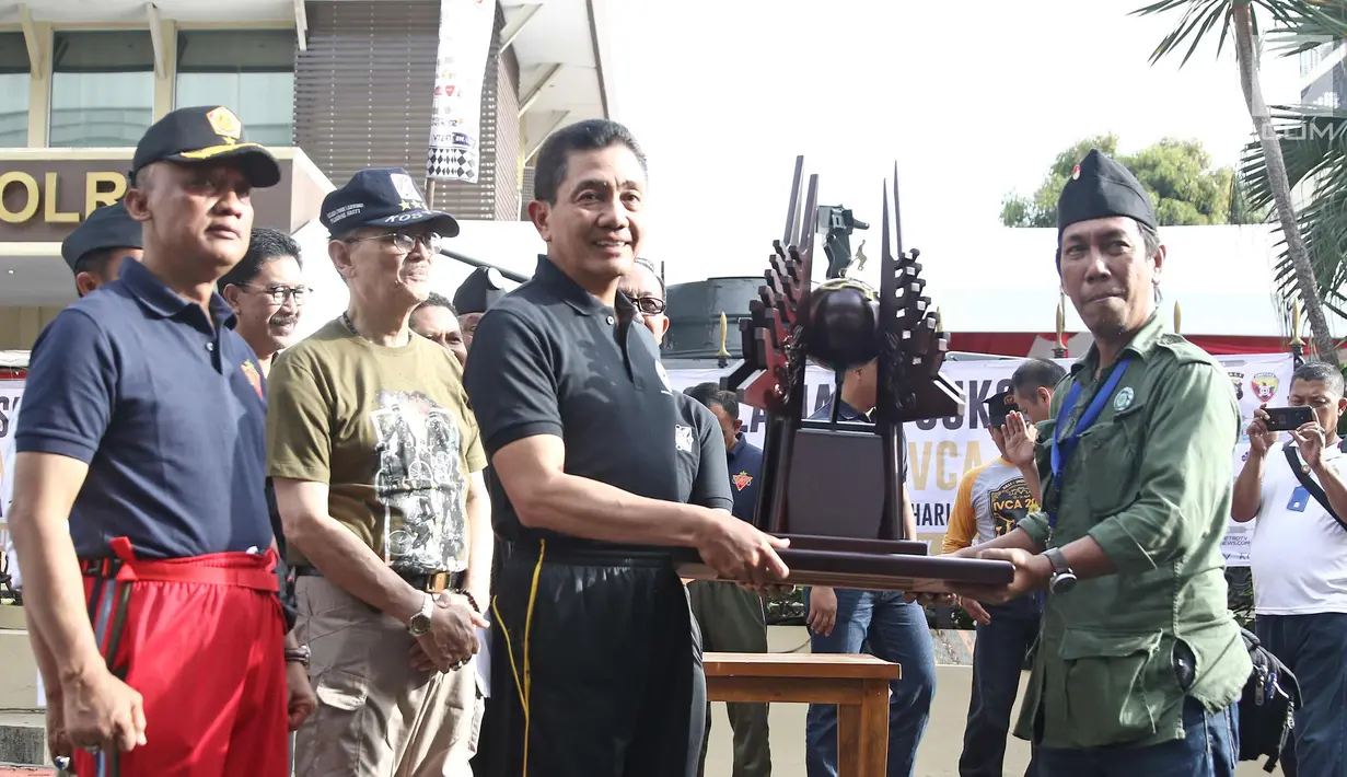 Irwasum Polri, Putut Eko Bayu Seno, menyerahkan secara simbolis tropi IVCA "Pulanggeni" ke koordinator lapangan kirab estafet IVCA Irmanop, saat pelepasan kirab estafet IVCA 2018 di Museum Polri, Jakarta, Minggu (25/3). (Liputan6.com/Herman Zakharia)