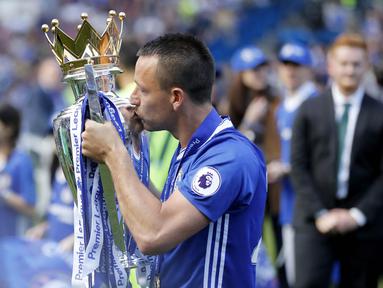 Kapten Chelsea, John Terry, mencium tropi Premier League 2016/2017 usai laga melawan Sunderland di Stamford Bridge, Minggu (21/5/2017). Terry resmi mengakhiri kiprahnya selama 22 tahun di Chelsea. (AP/Frank Augstein)