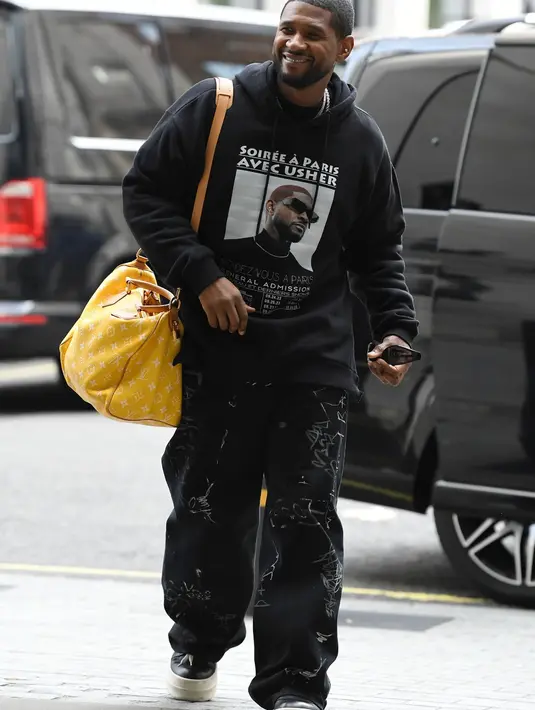 Nggak kalah kece, outfit jalanan dari Usher London satu ini bisa kamu tiru untuk sehari-hari. Ia memadukan hoodie dengan cargo pants dan tas LV Speedy P9 warna kuning. [Dok/Louis Vuitton]