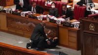 Wakil Ketua Banggar DPR RI Muhidin Muhammad Said terjatuh usai memberikan laporan hasil pembahasan RAPBN 2023 di Rapat Paripurna ke-26 Masa Persidangan V Tahun Sidang 2021-2022 di Gedung nusantara III, Jakarta, Kamis (30/6/2022). Belum diketahui kenapa Wakil Banggar Muhidin sampai terjatuh dan dibawa keruang medis. (Liputan6.com/Angga Yuniar)