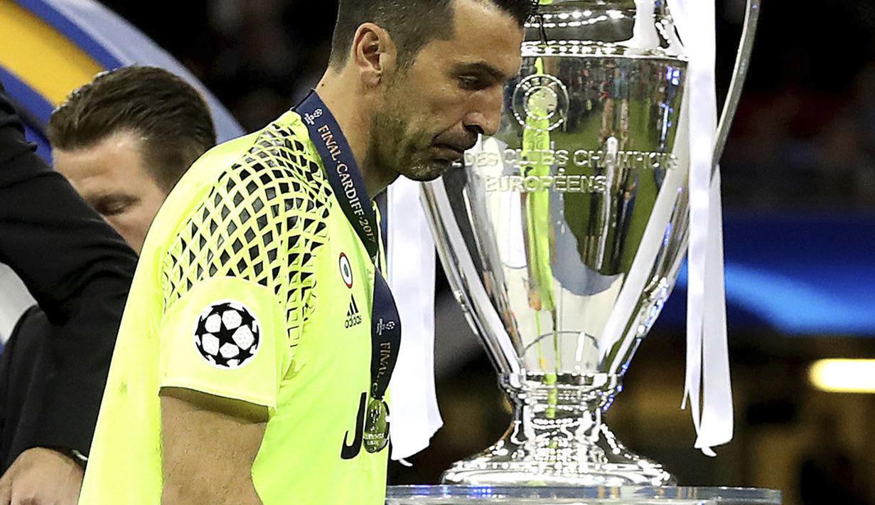 Gianluigi Buffon melintas dekat trofi Liga Champions, Juventus gagal merebut trofi tersebut setelah kalah dari Real Madrid 1-4. di Millennium Stadium, Cardiff, Wales (3/6/2017). (Nick Potts/PA via AP)