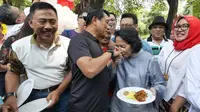 Kepala Staf Kepresidenan Moeldoko memberikan potongan tumpeng kepada sang istri, Koesni Harningsih saat merayakan ulang tahunnya yang ke-61 di Taman Suropati, Jakarta, Minggu (8/7). (Liputan6.com/Herman Zakharia)