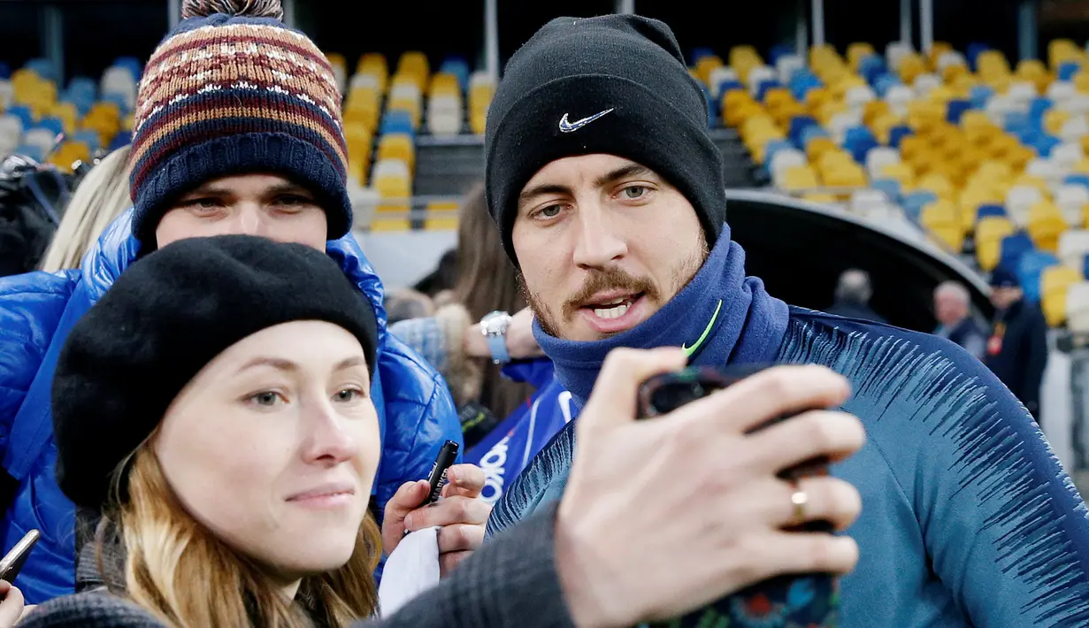 Penggemar wanita berselfie dengan gelandang Chelsea, Eden Hazard selama sesi pelatihan di NSC Olympiyskiy, Kiev, Ukraina (13/3). Pada leg pertama Chelsea menang telak atas Dynamo Kiev 3-0 di Stamford Bridge. (Reuters/Valentyn Ogirenko)
