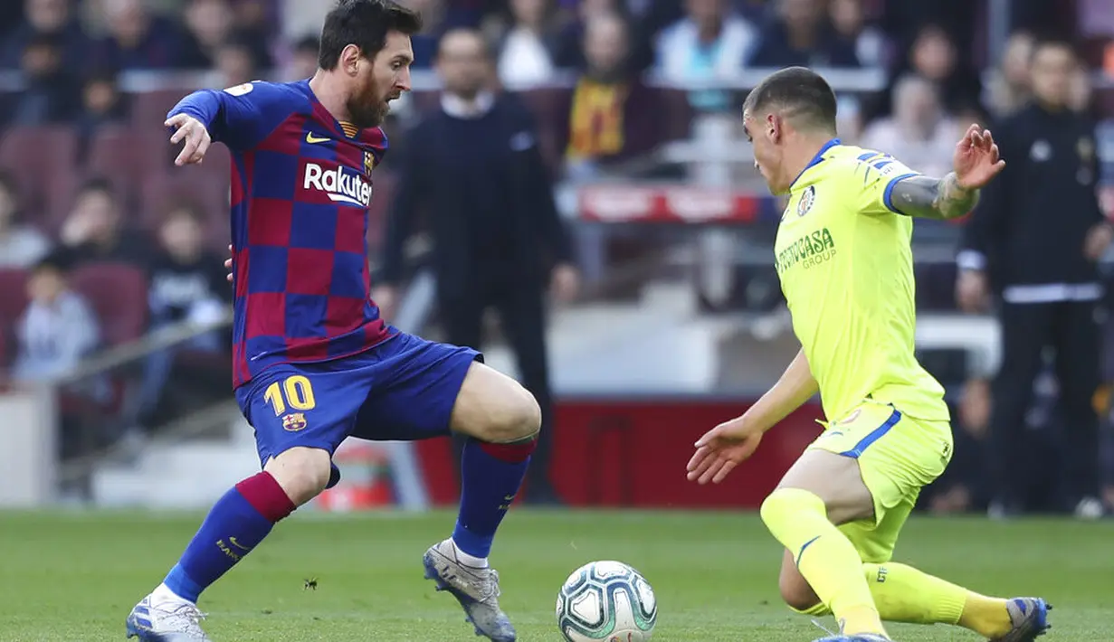 Striker Barcelona, Lionel Messi, berusaha melewati pemain Getafe, Mauro Arambarri, pada laga La Liga di Stadion Camp Nou, Sabtu (15/2/2020). Barcelona menang 2-1 atas Getafe. (AP/G.Garin)