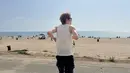 Tak cuma foto sepeda, Jaehyun NCT juga membagikan fotonya saat mengunjungi pantai. Dandanannya tetap nyantai, dengan kaos tanpa lengan dan sandal jepit. (Foto: Instagram/ _jeongjaehyun)