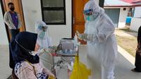 Salah satu tenaga kesehatan (nakes) di Sumsel yang melakukan rapid test antigen (Liputan6.com / Nefri Inge)