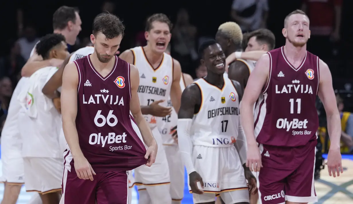 Pebasket Latvia, Kristers Zoriks (kiri) dan Rolands Smits tertunduk lesu setelah dikalahkan Jerman pada laga perempat final Piala Dunia FIBA 2023 di Mall of Asia Arena, Manila, Filipina pada Rabu (06/09/2023). Sebelumnya, Latvia menjadi tim debutan penuh kejutan saat bermain di Indonesia. Mereka berhasil mengalahkan sejumlah tim unggulan seperti juara bertahan Spanyol. (AP Photo/Michael Conroy)