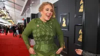 Penyanyi Inggris, Adele tertawa sambil berjalan di karpet merah Grammy Awards 2017 di Los Angeles, Minggu (12/2). Di Grammy Awards ini, Adele bersaing ketat dengan para musisi lainnya di lima kategori. (CHRISTOPHER POLK/GETTY IMAGES NORTH AMERICA /AFP)