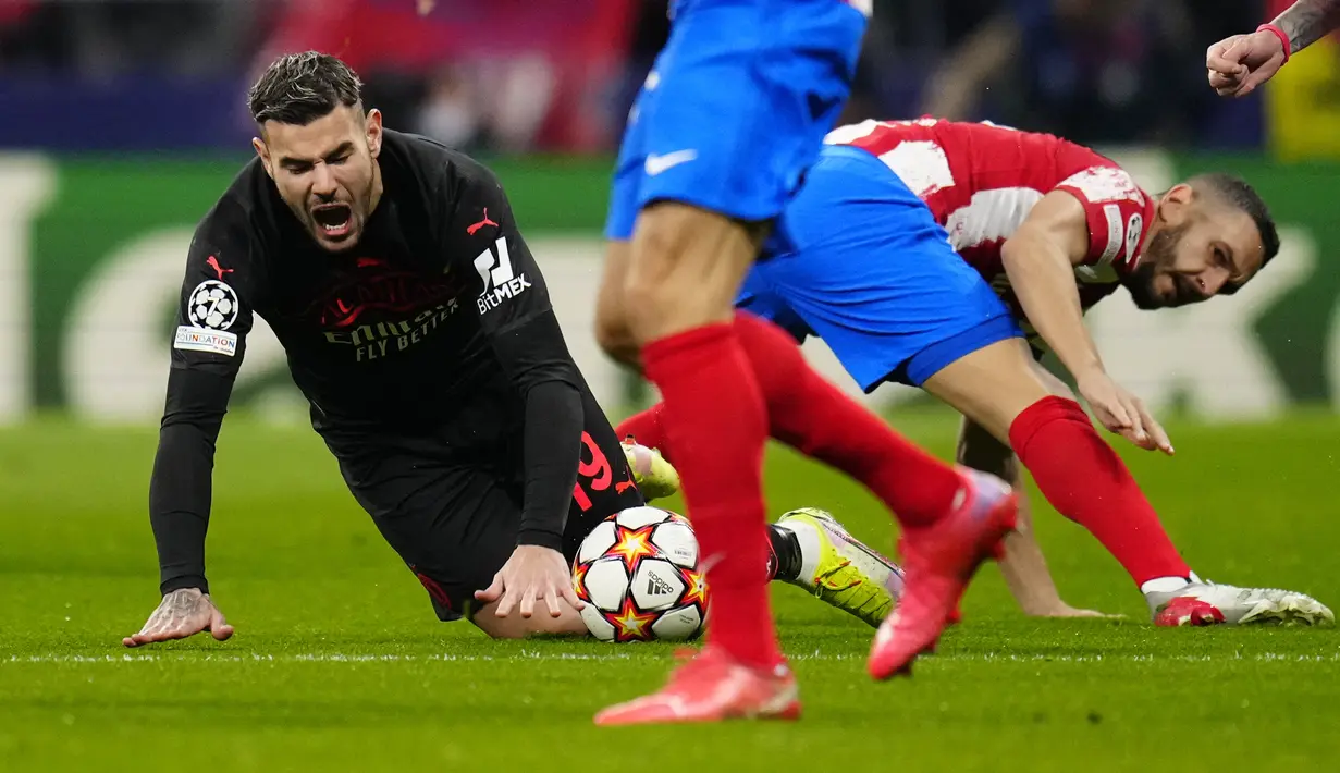 Bek AC Milan Theo Hernandez jatuh di sebelah gelandang Atletico Madrid Koke pada laga kelima Grup B Liga Champions 2021/2022 di Stadion Wanda Metropolitano, Kamis (25/11/2021) dini hari WIB. AC Milan secara mengejutkan menaklukkan tuan rumah Atletico Madrid 1-0. (AP Photo/Manu Fernandez)