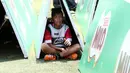 Seorang anak berteduh saat mengikuti Milo Football Clinic di Lapangan Sepak Bola Pertamina, Simprug, Jakarta, Minggu (24/4/2016). (Bola.com/Nicklas Hanoatubun)