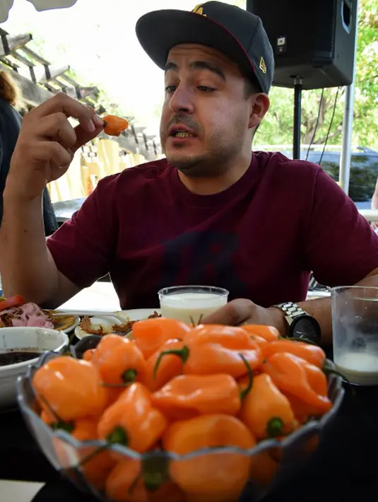 Mario Monez, salah satu peserta lomba saat menyelesaikan makan 60 cabai Habanero dalam Habanero Eating Contest di Restoran Chichen Itza, Los Angeles, Minggu (21/6). (AFP PHOTO/Mark RALSTON)
