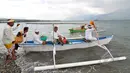 Sejumlah Umat Hindu membawa benda-benda sakral ke laut saat upacara Melasti menjelang Hari Raya Nyepi Tahun Saka 1937 pada Sabtu (21/3) mendatang  di pantai Dupa, Palu, Sulawesi  Tengah, Kamis (19/3/2015). (Liputan6.com/Dio Pratama)