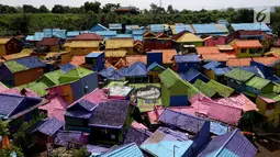 Suasana atap rumah kampung warna-warni dari atas jembatan di Kelurahan Kesatrian, Kota Malang, Minggu (5/11). Ratusan rumah yang di cat gambar tersebut untuk menarik wisatawan. (Liputan6.com/Fery Pradolo)