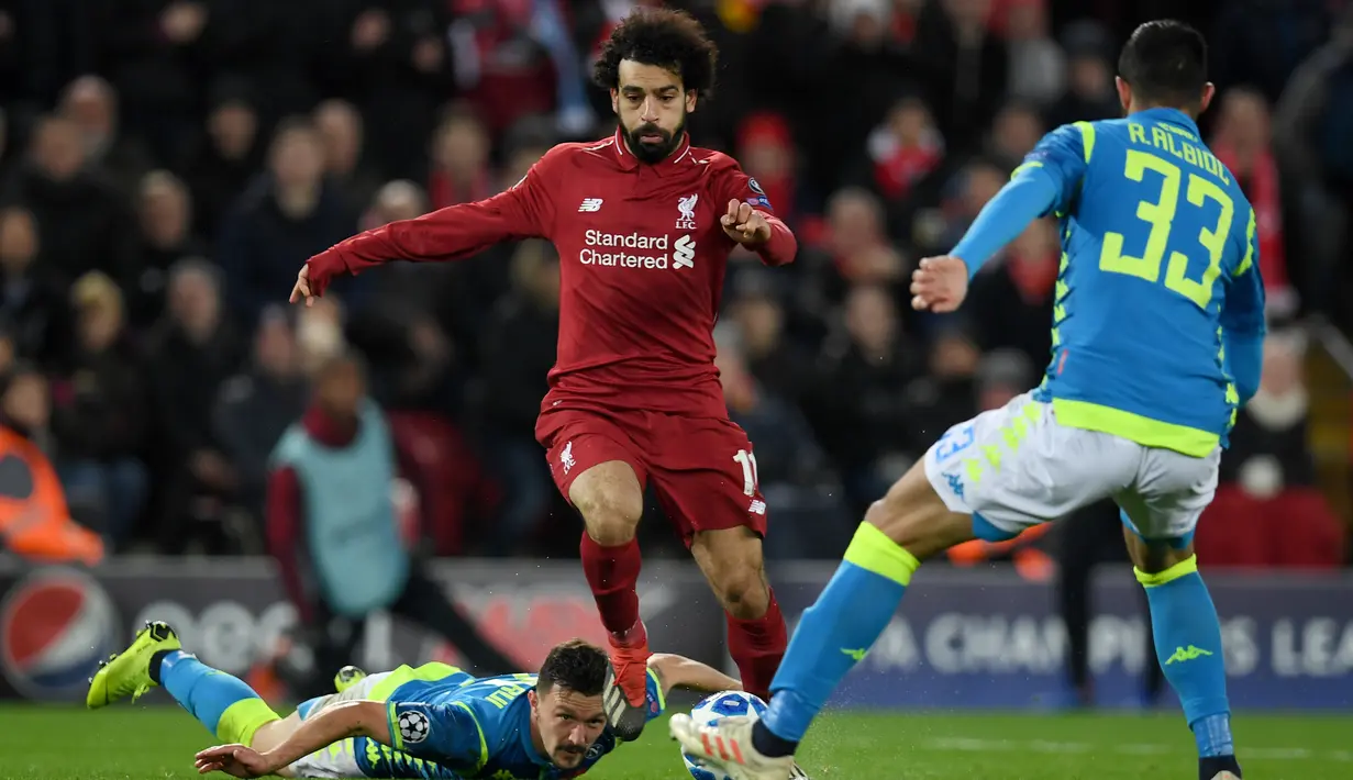Gelandang Liverpool, Mohamed Salah, berusaha melewati bek Napoli, Raul Albiol, pada laga Liga Champions di Stadion Anfield, Liverpool, Selasa (11/12). Liverpool menang 1-0 atas Napoli. (AFP/Paul Ellis)