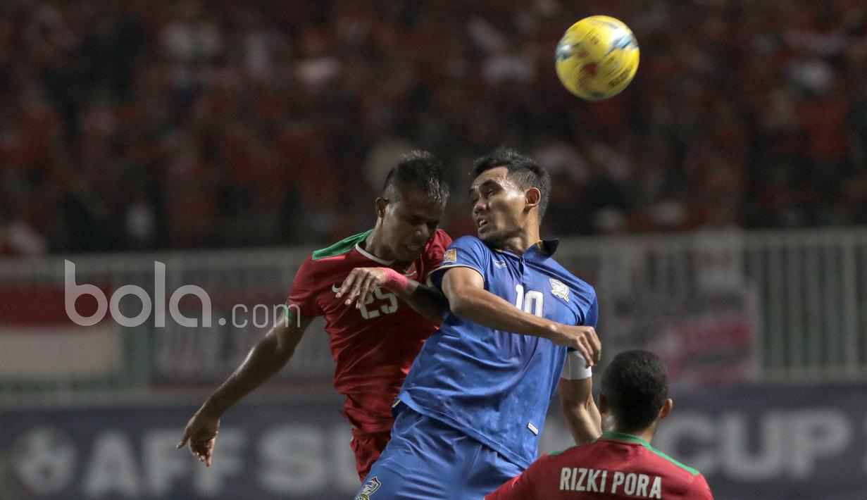 Manahati Lestusen saat berduel dengan pemain Teerasil Dangda pada laga Final Piala AFF 2016 di Stadion Pakansari, Bogor, (14/12/2016). (Bola.com/Nicklas Hanoatubun)