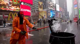 Michael Vante membersihkan salju di New York Times Square, (21/3). Badai salju yang melanda sebagian Amerika Serikat telah membawa salju dan angin kencang. (AP Photo / Mary Altaffer)
