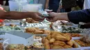 Sejumlah warga berburu hidangan untuk berbuka puasa di sepanjang jalan Benhil, Jakarta, Kamis (18/6/2015). Tampak seorang warga membayar camilan yang telah dibelinya (Liputan6.com/Johan Tallo)