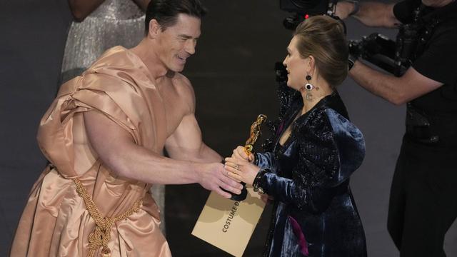 John Cena dalam Piala Oscar 2024 menyerahkan trofi kepada Holly Wadidington. (AP Photo/Chris Pizzello)