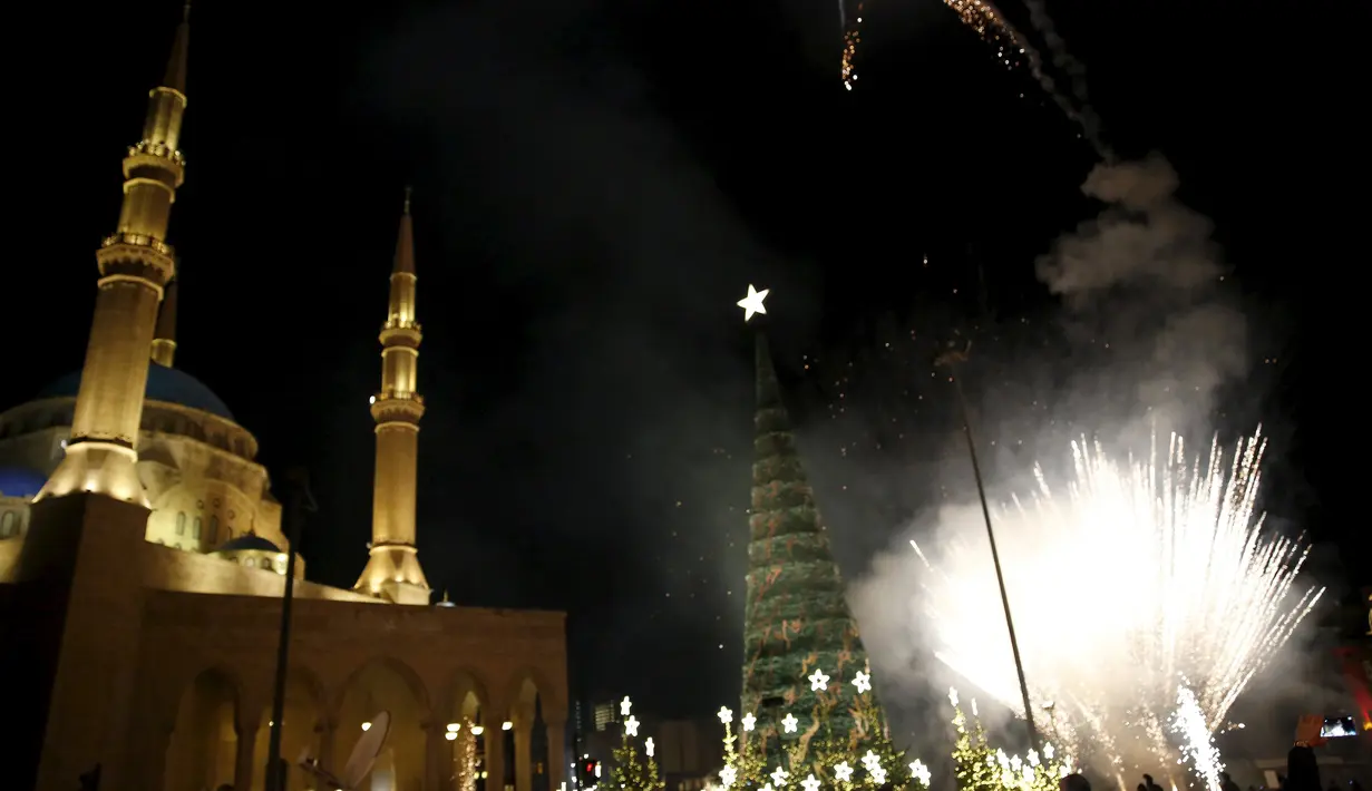 Kembang api dinyalakan di dekat pohon Natal yang dirancang oleh desainer Lebanon, Elie Saab di depan Masjid Al-Amin, di pusat kota Beirut, 12 Desember 2015. (REUTERS/Jamal Saidi)