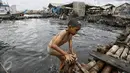 Seorang anak seusai bermain air di kawasan pantai penuh sampah yang terbawa arus di Muara Angke, Jakarta, Rabu (10/2). Genangan sampah yang terbawa arus oleh angin musim barat ini tak menyurutkan anak-anak untuk bermain air. (Liputan6.com/Faizal Fanani)