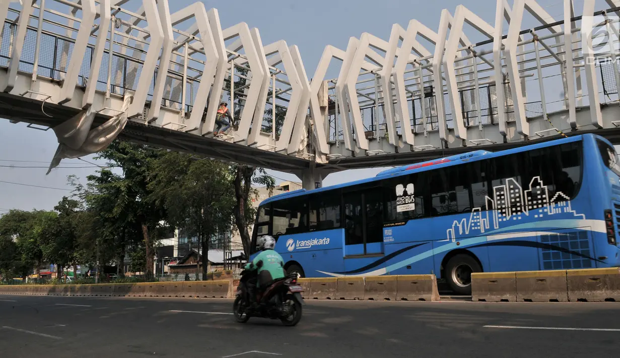Bus Transjakarta melintas di bawah Skybridge Stasiun LRT Velodrome-Halte Transjakarta Pemuda, Jakarta, Selasa (11/6/2019). Pengoperasian LRT Kelapa Gading-Velodrome kembali diundur karena belum selesainya pembangunan Skybridge LRT Velodrome-Halte Transjakarta Pemuda. (merdeka.com/Iqbal Nugroho)