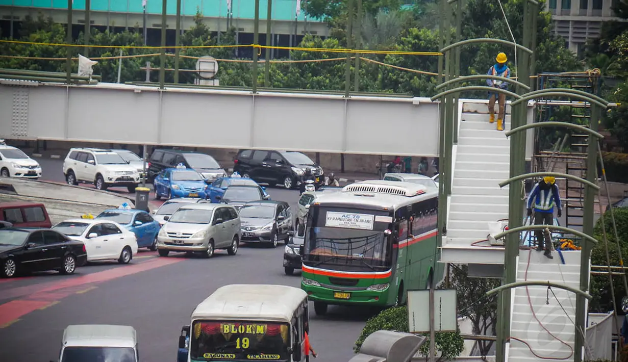 Sejumlah kendaraan melintas di bawah JPO Bundaran HI yang sedang adalam tahap penyelesaian, Jakarta, Selasa (26/8/14). (Liputan6.com/Faizal Fanani)