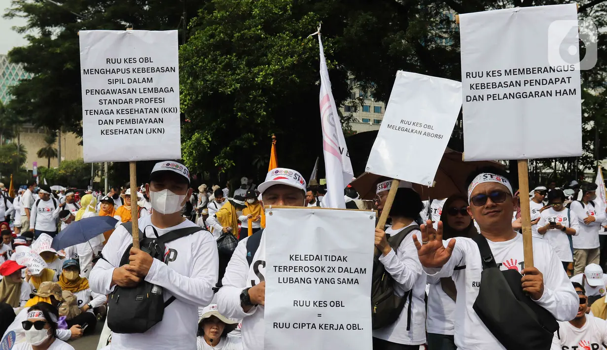 Massa kompak memakai baju berwarna putih dengan atribut profesi masing-masing. (Liputan6.com/Herman Zakharia)