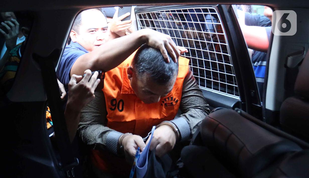 Wakil Menteri Imigrasi dan Pemasyarakatan (Wamen Imipas), Silmy Karim, dibantu petugas saat masuk ke dalam mobil tahanan usai menjalani pemeriksaan intensif di Gedung Merah Putih Komisi Pemberantasan Korupsi (KPK), Jakarta, Kamis (4/6/2026). (Liputan6.com/Helmi Fithriansyah)