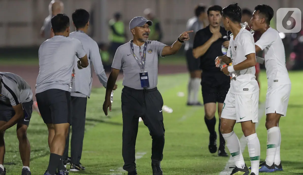 Pelatih Timnas Indonesia U-19, Fakhri Husaini (tengah) memberi arahan pada timnya saat laga melawan Hong Kong pada kualifikasi Grup K Piala AFC U-19 2020 di Stadion Madya Gelora Bung Karno, Jakarta, Jumat (8/11/2019). Indonesia unggul 4-0. (Liputan6.com/Helmi Fithriansyah)
