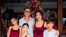 Indah Kalalo dan keluarga mengambil warna Santa Claus sebagai dresscode foto keluarga. Indah dan kedua putrinya kenakan dress satin berwarna merah, sedangkan suami dan putranya kompak padukan kemeja putih dan celana pendek merah [@indahkalalo]