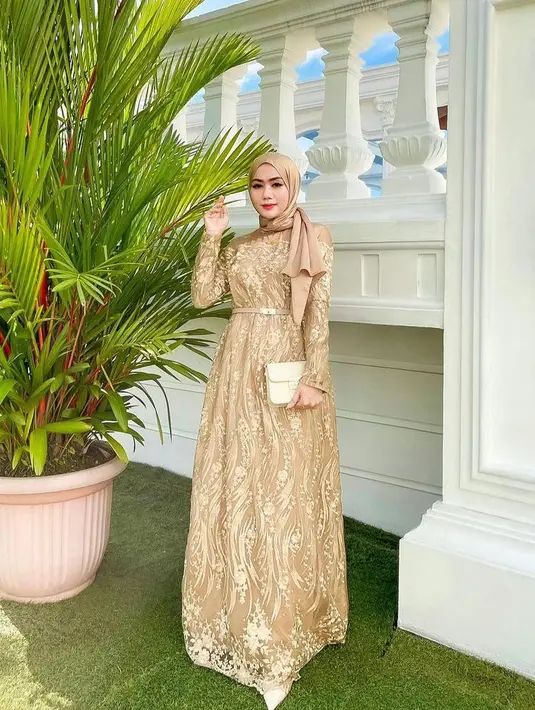 Kamu juga bisa pakai gamis brokat warna cokelat keemasan seperti ini. Tambahkan belt untuk membuat kesan tubuh yang lebih ramping. (Instagram/yollaanggitaaa).