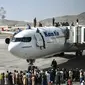 Orang-orang Afghanistan naik ke atas sebuah pesawat saat mereka menunggu di bandara Kabul (16/8/2021). Bandara internasional di Kabul dilanda kekacauan dan kemacetan lalu lintas yang parah. (AFP/Wakil Kohsar)