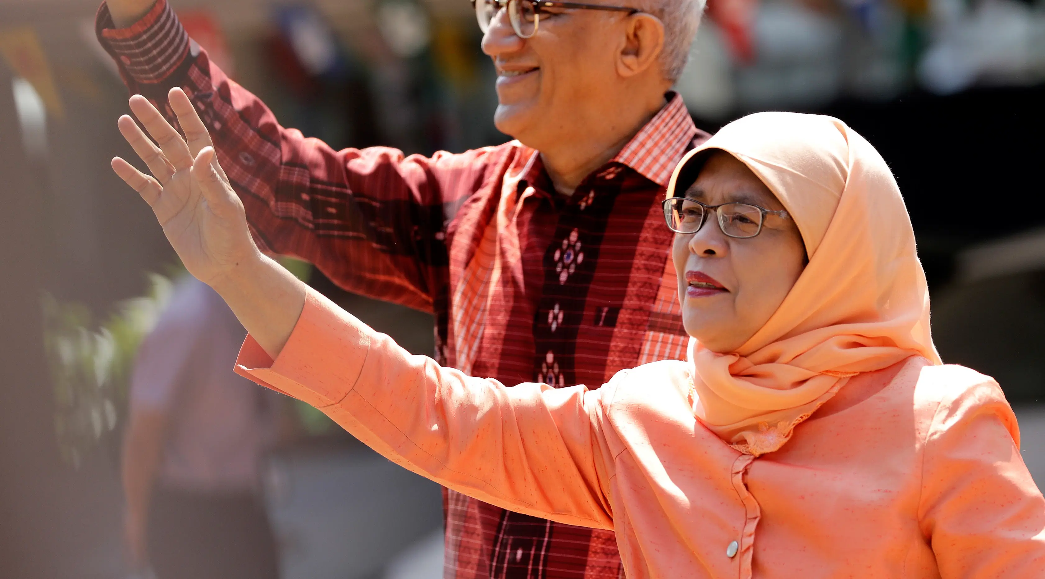 Halimah Yacob melambaikan tangan ke pendukungnya saat tiba untuk menyerahkan berkas pencalonan presiden di Singapura, Rabu (13/9). Halimah telah malang melintang di perpolitikan Singapura, serta menjadi ketua parlemen sejak 2013. (AP Photo/Wong Maye-E)
