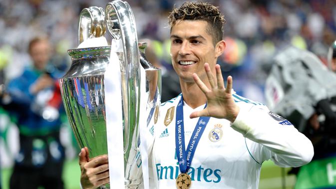 Penyerang Real Madrid Cristiano Ronaldo menggendong trofi sambil menunjukkan lima jarinya usai menjadi juara Liga Champions di Stadion NSK Olimpiyskiy, Ukraina (26/5). (AP/Pavel Golovkin)