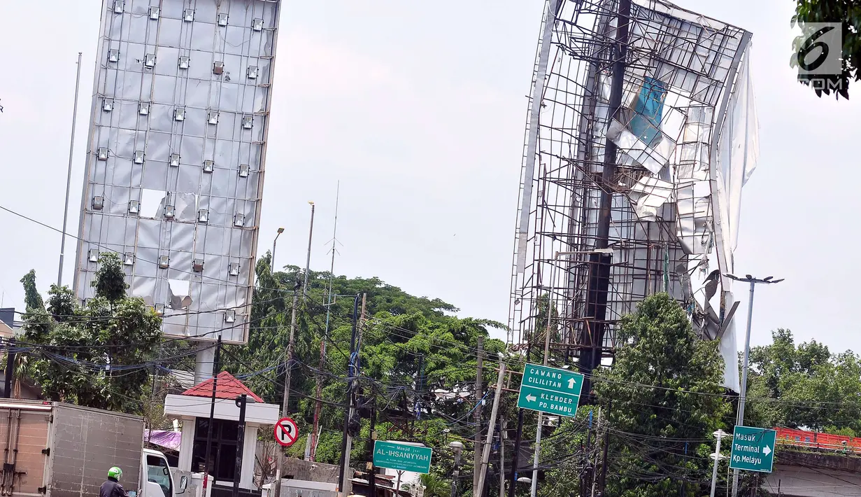 Kondisi papan reklame yang hampir roboh yang berada di kawasan Terminal Kampung Melayu, Jakarta (2/10). Hujan deras disertai angin kencang yang mengguyur Ibu Kota kemarin membuat papan reklame ini hampir roboh.(Liputan6.com/Helmi Afandi)
