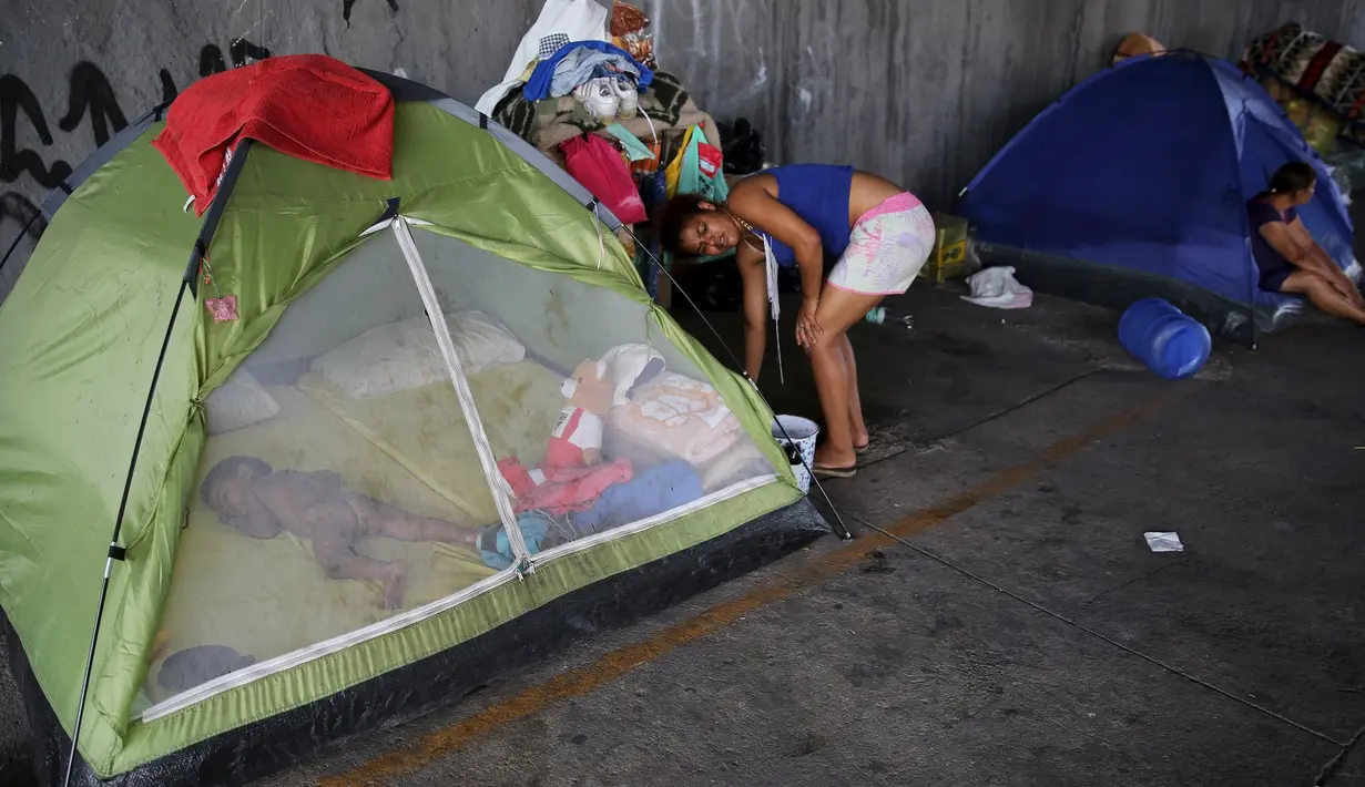Seorang anak tertidur disebuah tenda yang berada dibawah jembatan, Sao Paulo, Brasil, (18/12). Mereka adalah keluargatidak mampu yang tidak memiliki rumah. (REUTERS/Nacho Doce)