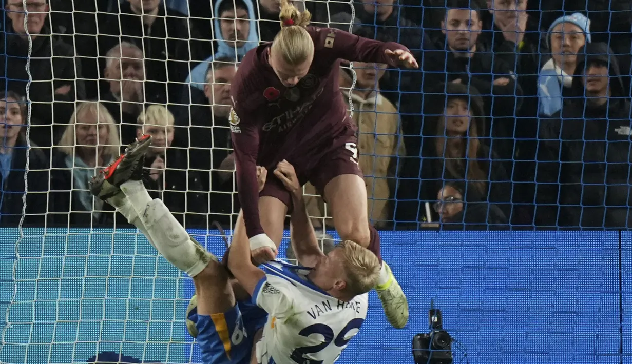 Pemain Manchester City, Erling Haaland (atas) bersitegang dengan pemain Brighton, Paul Van Hecke pada laga lanjutan Liga Inggris 2024/2025 yang berlangsung di American Express Community Stadium, Brighton, Inggris, Minggu (10/11/2024) WIB. (AFP/Glyn Kirk)