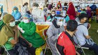 Warga menerima vaksin virus corona COVID-19 Sinovac di klinik vaksinasi massal darurat di lapangan sepak bola di Surabaya, Jawa Timur, Selasa (6/7/2021). Indonesia tengah memerangi gelombang infeksi baru yang belum pernah terjadi sebelumnya. (JUNI KRISWANTO/AFP)