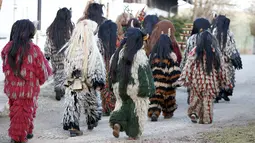 Rombongan peserta yang mengenakan kostum iblis bersiap mengikuti parade tardisional Perchtenlauf di Osterseeon dekat Munchen, Jerman (17/12). Acara ini bertujuan untuk mengusir hantu-hantu musim dingin. (Reuters/Michaela Rehle)