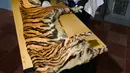 Petugas konservasi satwa liar memeriksa kulit harimau Sumatra yang disita dari seorang pemburu di Banda Aceh, Aceh, Rabu (12/12). Kuit harimau itu hasil sitaan dari pemburu yang mencoba menjual tubuh satwa terancam punah itu. (CHAIDEER MAHYUDDIN/AFP)