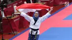 Atlet Taekwondo putri Indonesia, Defia Rosmaniar mengibarkan bendera Merah Putih saat merayakan kemenangan atas Salahshouri Marjan (Iran) pada Final Women Individual Poomsae di JCC, Jakarta, Minggu (19/8). (Liputan6.com/Helmi Fithriansyah)