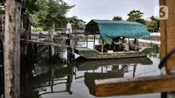 Warga bersiap menaiki perahu eretan untuk menyeberang di Kali Sunter, Rawa Badak, Jakarta, Rabu (20/1/2021). Kebanyakan penumpang adalah pedagang, pengunjung pasar, dan anak sekolah. (merdeka.com/Iqbal S. Nugroho)