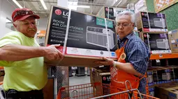 Manager toko mengambilkan pendingin udara untuk pelanggan menjelang gelombang panas di toko perlengkapan Home Depot di Seattle, Selasa (1/8). Suhu panas mendekati 100 derajat diperkirakan terjadi di wilayah itu pada Kamis 3 Agustus. (AP/Elaine Thompson)
