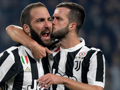 Pemain Juventus, Gonzalo Higuain dan rekan setimnya, Herzegovina Miralem Pjanic merayakan gol ke gawang SPAL pada lanjutan Serie A Italia di Allianz Stadium, Kamis (26/10). Juventus menang besar saat menjamu SPAL dengan skor 4-1. (MIGUEL MEDINA/AFP)