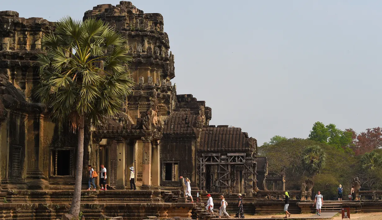 <p>Sejumlah wisatawan berjalan di Candi Angkor Wat, Provinsi Siem Reap, Kamboja, Kamis (5/3/2020). Menurut World Travel and Tourism Council, wabah virus corona (COVID-19) membuat sektor pariwisata dunia kehilangan USD 22 miliar. (TANG CHHIN Sothy/AFP)</p>