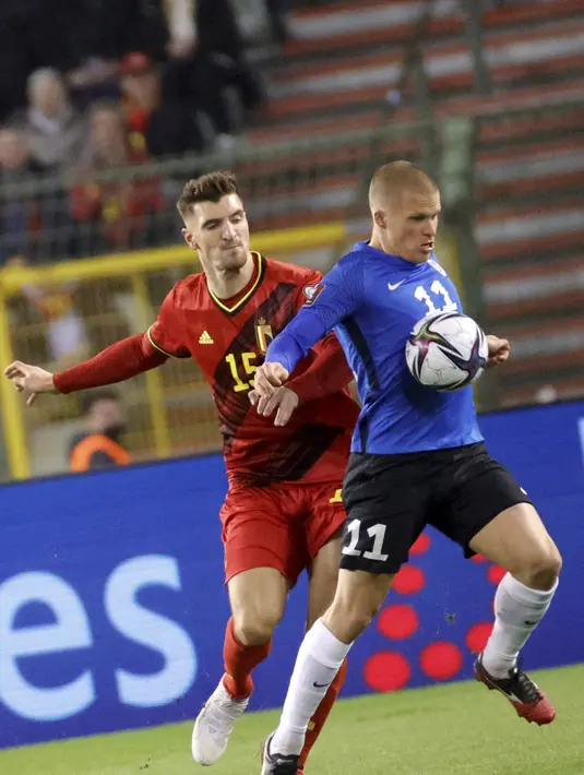 Pemain Estonia, Hindrek Ojamaa mengontrol bola dari kawalan bek Belgia, Thomas Meunier pada pertandingan grup E kualifikasi Piala Dunia 2022 di stadion King Baudouin di Brussels, Minggu (14/11/2021). Belgia menang atas Estonia 3-1. (AP Photo/Olivier Mattys)