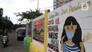 Warga melintas di depan mural yang berisi pesan 3M di Jakarta, Rabu (11/11/2020). Mural tersebut dibuat untuk mengingatkan masyarakat agar menerapkan protokol kesehatan saat beraktivitas sehari-hari. (Liputan6.com/Herman Zakharia)
