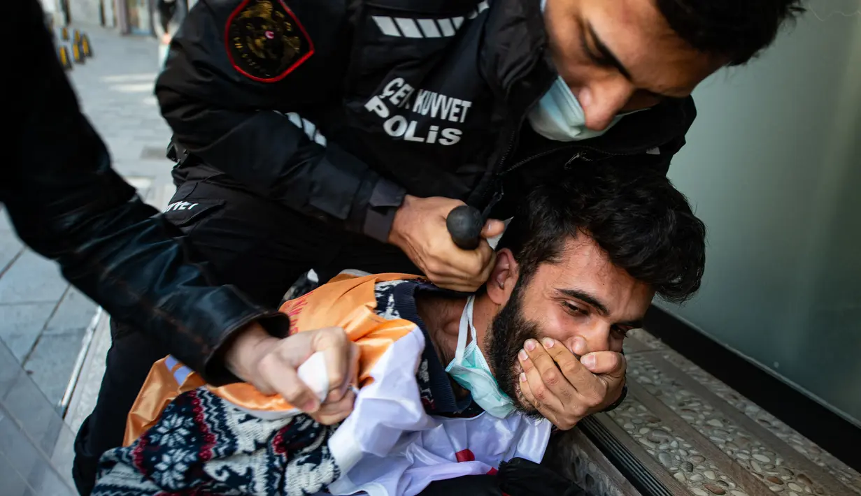 Polisi Turki menahan seorang demonstran saat mereka bentrok selama unjuk rasa May Day yang menandai Hari Buruh Internasional di Istanbul, pada Sabtu (1/5/2021). Dalam rangka memperingati hari buruh tersebut, biasanya para buruh turun ke jalan menyuarakan aspirasinya. (Yasin AKGUL / AFP)