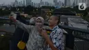 Pengunjung berfoto dari Skywalk Senayan Park, Jakarta, Rabu (29/12/2021). Kawasan yang menyajikan pemandangan lanskap perkotaan itu menjadi alternatif destinasi wisata Jakarta yang instagramble dengan spot foto yang beragam. (merdeka.com/Imam Buhori)